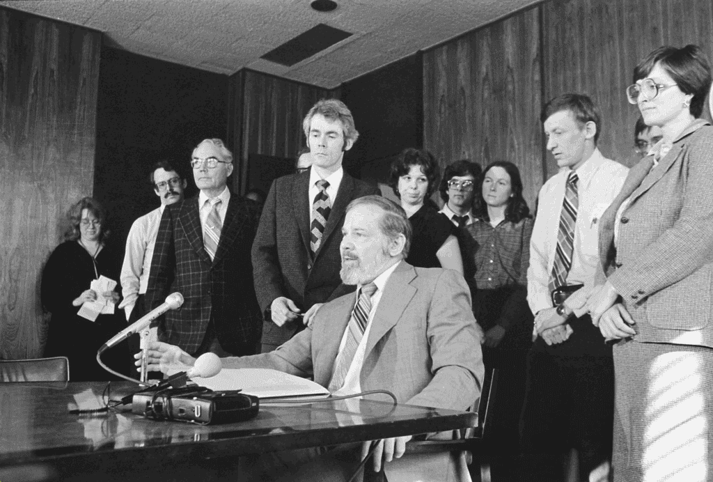 Men and women around a table with a microphone 