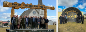 Staff and Trustees in Nome, Alaska standing at the end of the Iditarod race and in front of a gold pan.